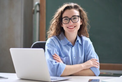 Aspiring special educator smiling at desk with laptop