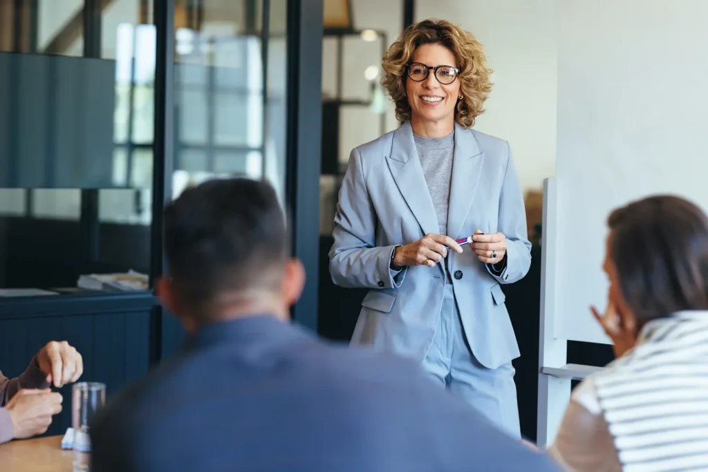 Woman in a business suit speaking to colleagues during a leadership training session